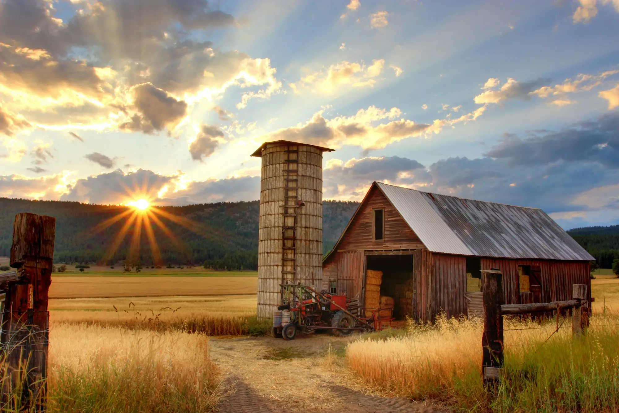 Weathered barn and stone silo at sunset on the plains